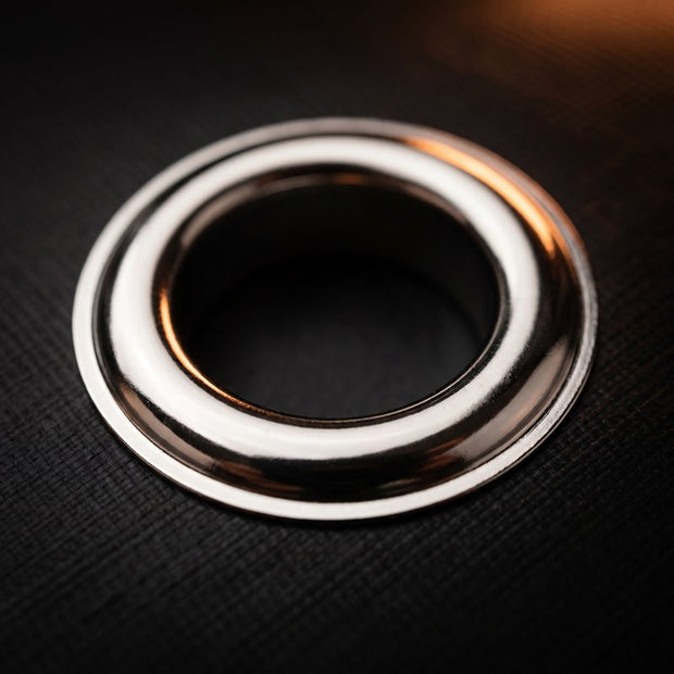 Close-up of a polished silver metal grommet set in banner vinyl