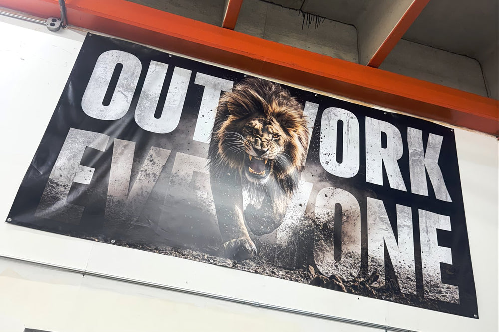 Outwork Everyone banner hanging in Joey's shop